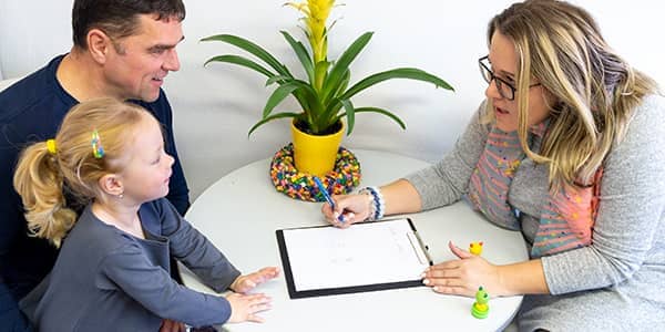 Father and toddler daughter in therapist office during a counselling meeting.
