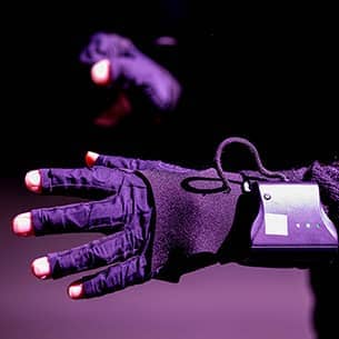 A close up of a person's hand wearing an extended reality glove