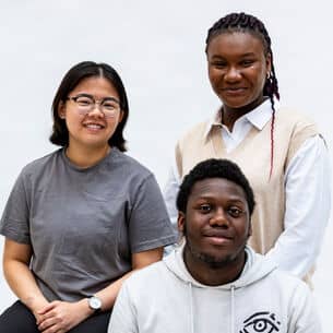 Three Global Majority peopel smiling.