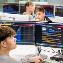 A classroom of students working on computers, each using the same software.