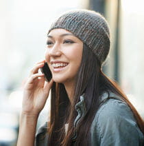 A smiling student talking on a mobile phone.