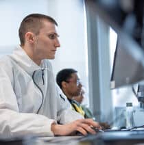 A young man concentrating while working at a computer.